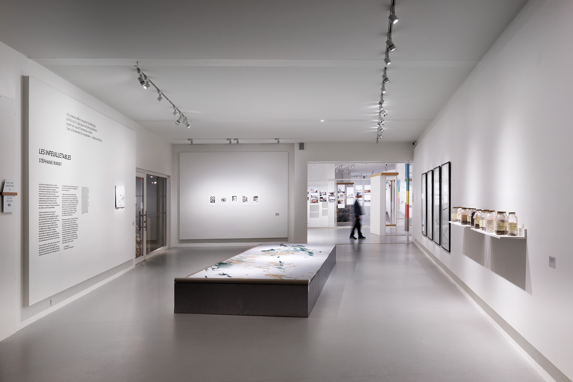 Salle d'exposition moderne avec des œuvres accrochées et un espace lumineux.